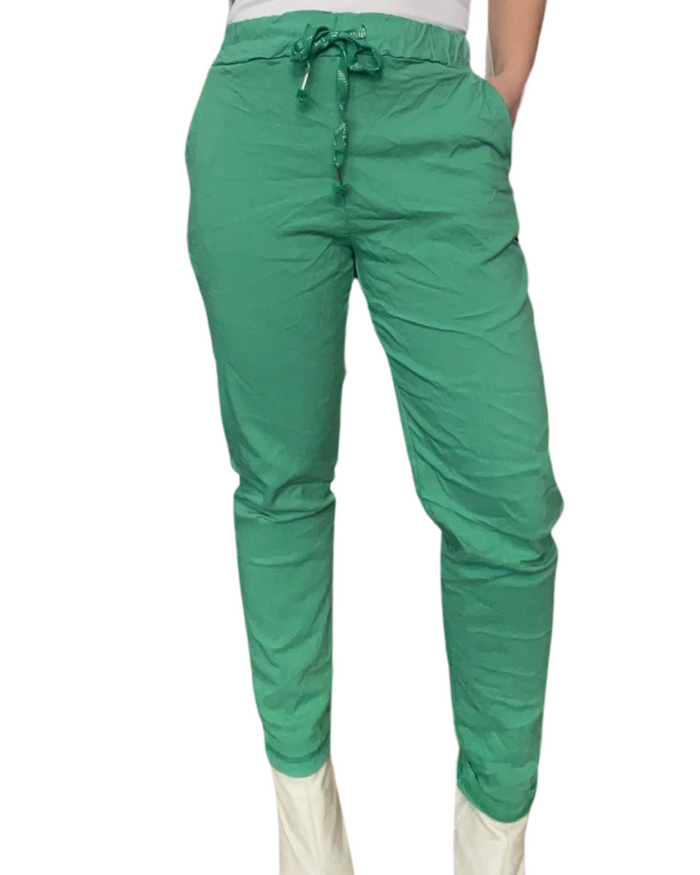 Pantalon vert pour femme à taille élastique avec cordon et  bottes beiges.