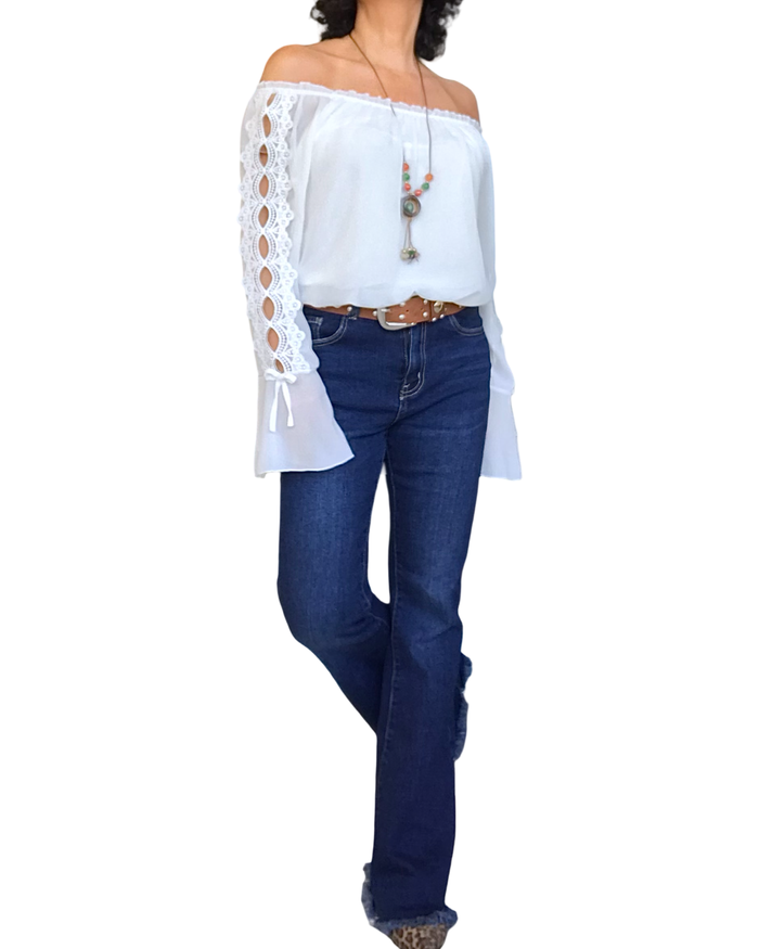 Blouse en voile unie blanche, dentelle le long des manches et volant au bas