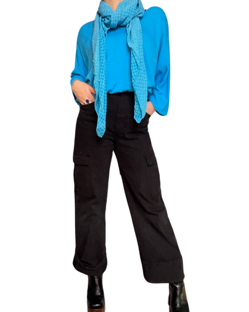 Chandail bleu femme à manche longue col en v avec jeans cargo noir, foulard bleu et bottes noires.