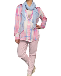 Chemise rose pour femme imprimé de carreaux abstraits avec foulard, camisole blanche, pantalons lilas et bottes beiges.