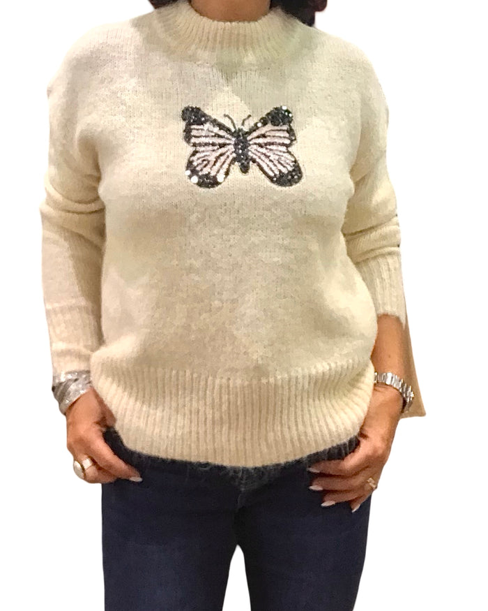 Chandail col montant beige en tricot avec un appliqué de papillon