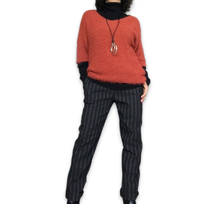 Pantalon noir à rayures ton sur ton à taille élastique avec chandail en tricot manche courte orange brulé, col roulé noir et collier