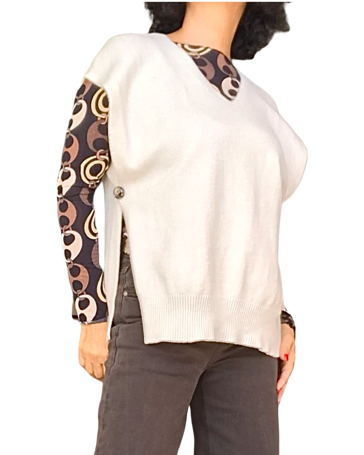 Débardeur en tricot beige col V porté sur un haut à motif de cercles, ouverture boutonnée sur le côté