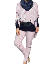 Blouse rose over size pour femme à motifs avec foulard, chandail manche longue, ceinture, pantalons lilas et talons hauts.