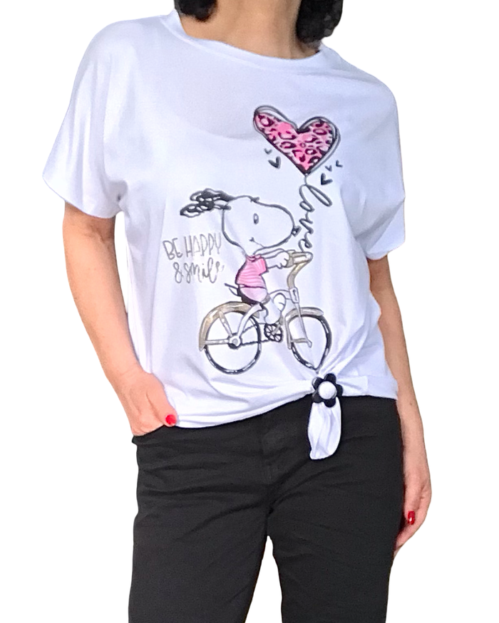 T-shirt blanc Snoopy en rose bonbon et noir qui fait du vélo  avec l’inscription « Be happy and smile » en doré
