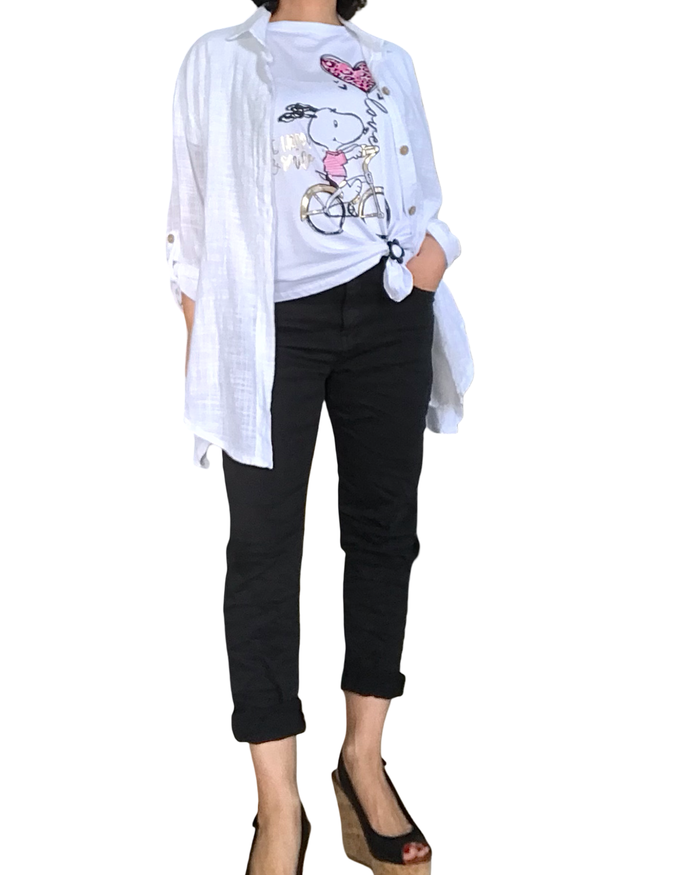 T-shirt blanc Snoopy en rose bonbon et noir qui fait du vélo  avec l’inscription « Be happy and smile » en doré