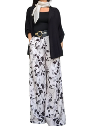 Pantalon palazzo crème à fleurs noires, taille élastique.  Agencer avec une camisole gainante noire, une sur chemise noire à capuchon, un une ceinture élastique, large en similicuir noir et un foulard uni beige.