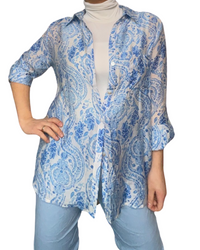 Chemise blanche pour femme imprimé de motifs floraux avec col roulé et pantalons bleu ciel.