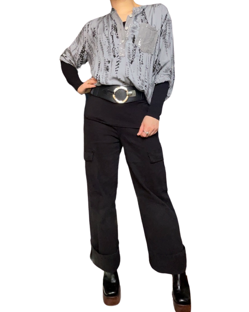 Jeans pour femme droits cargo à taille haute noir avec blouse grise, ceinture, chandail noir à manche longue et bottes noires.