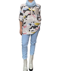 Blouse pour femme avec imprimé camouflage manche 3/4 avec foulard, pantalons bleu ciel et bottes blanches.