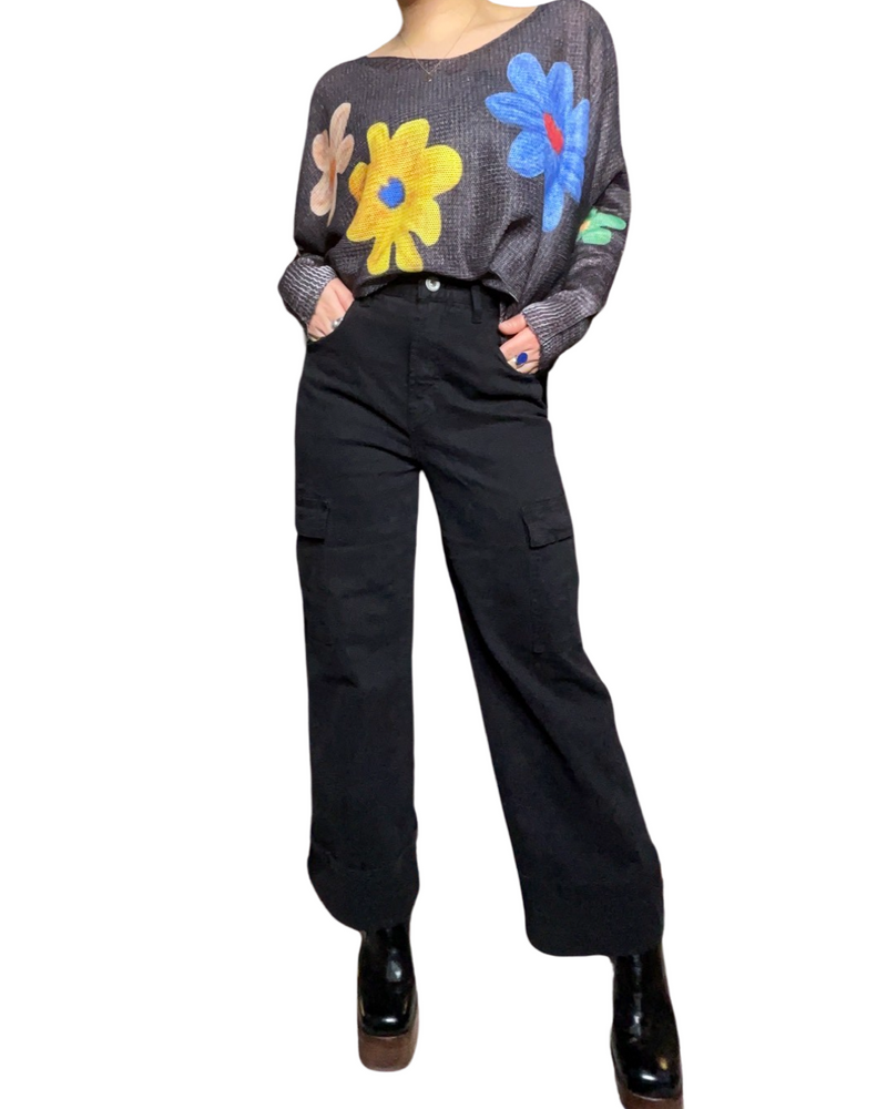 Chandail pour femme à manche longue gris avec imprimé de fleurs avec pantalons cargo et bottes noires.