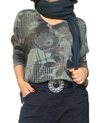 T-shirt kaki col V à grosses fleurs noires et brunes porté avec foulard noir et ceinture à boucle argentée