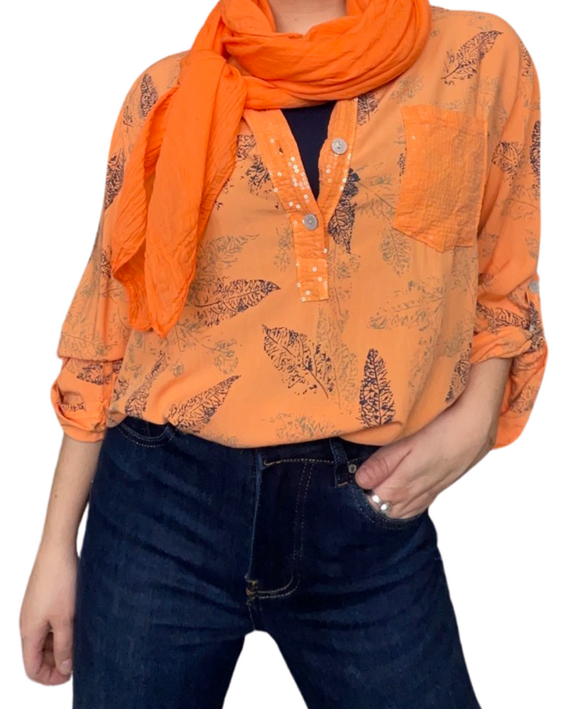 Foulard femme léger orange 20% soie avec blouse orange, camisole noire et jeans flare bleu foncé.