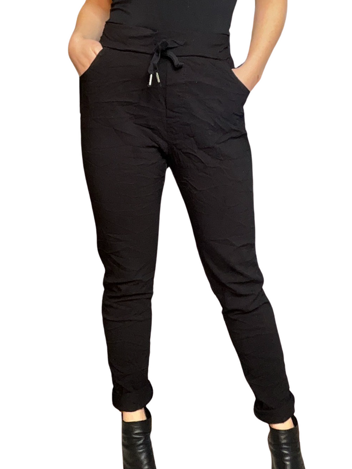 Pantalon noir pour femme à taille élastique avec cordon et talons hauts.