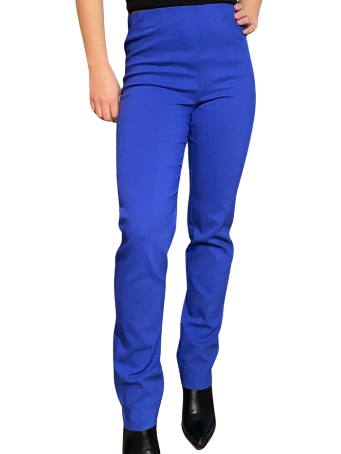 Pantalon slim bleu pour femme à taille haute avec camisole noire et bottes noires.