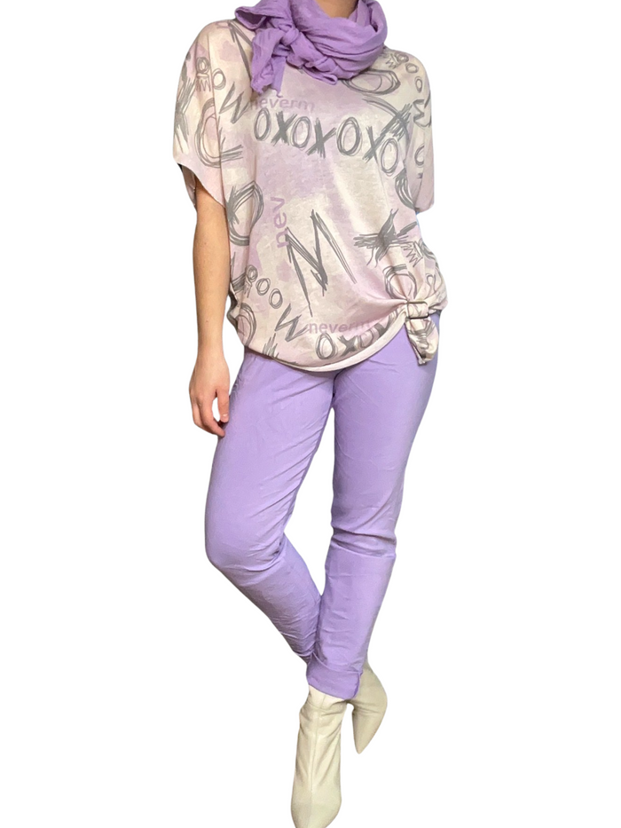 Chandail pour femme à manche courte avec imprimé d'écritures avec pantalon lilas, foulard lilas et bottes beige.