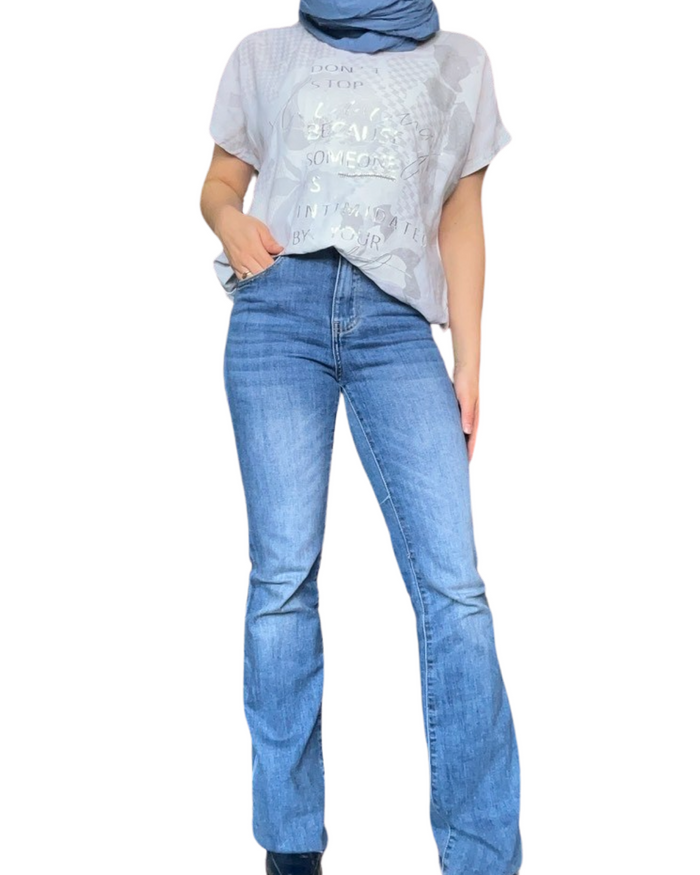 T-shirt blanc pour femme avec imprimé d'écritures argentées avec jean flare.