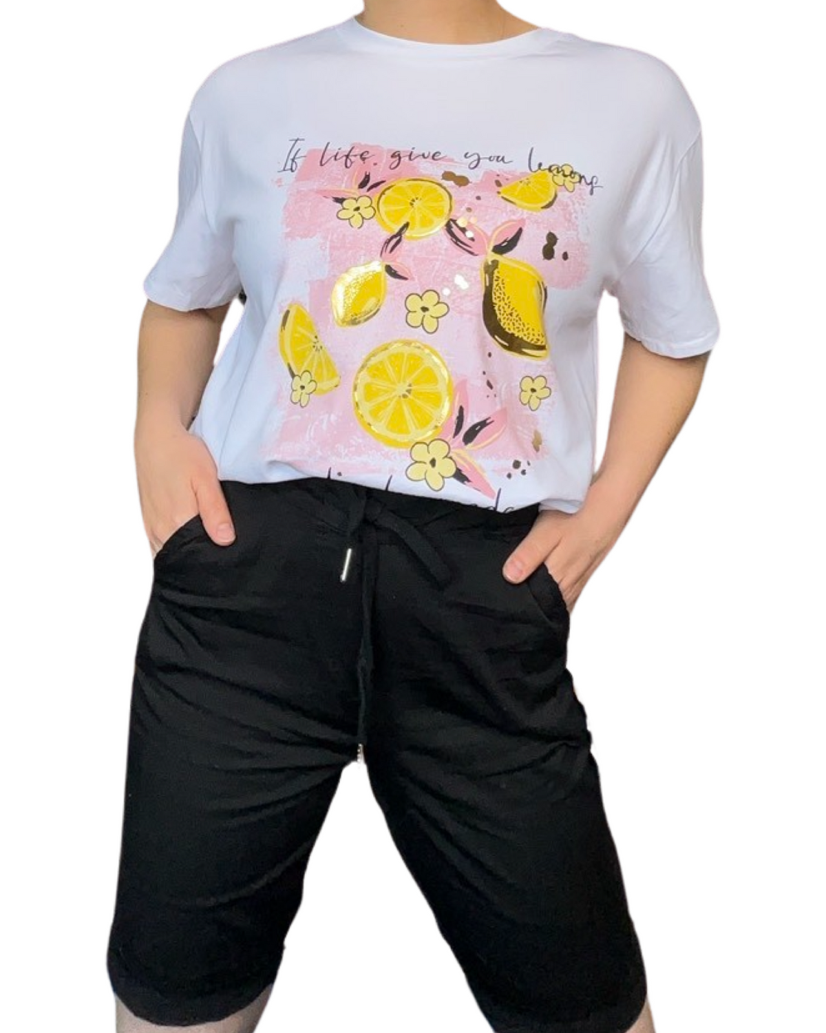 T-shirt blanc pour femme avec imprimé de citrons jaunes portée à l'intérieur du bermuda.