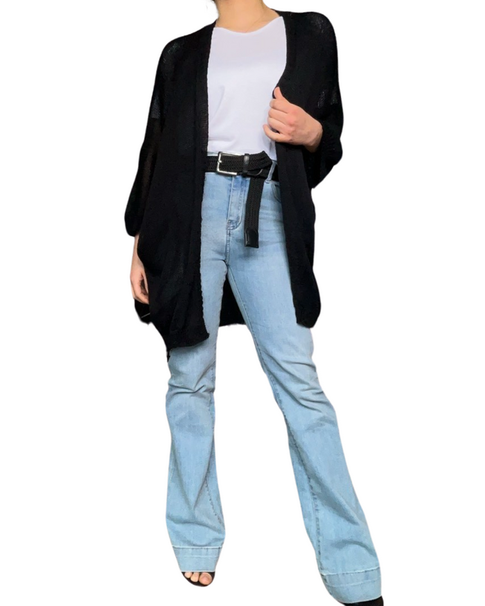 Cardigan noir uni en maille pour femme avec ceinture noire et jean flare.