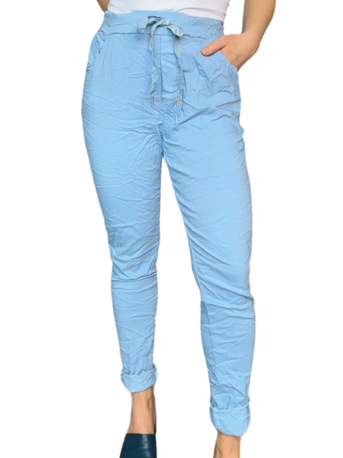 Pantalon bleu ciel pour femme à taille élastique avec cordon avec camisole gainante blanche.