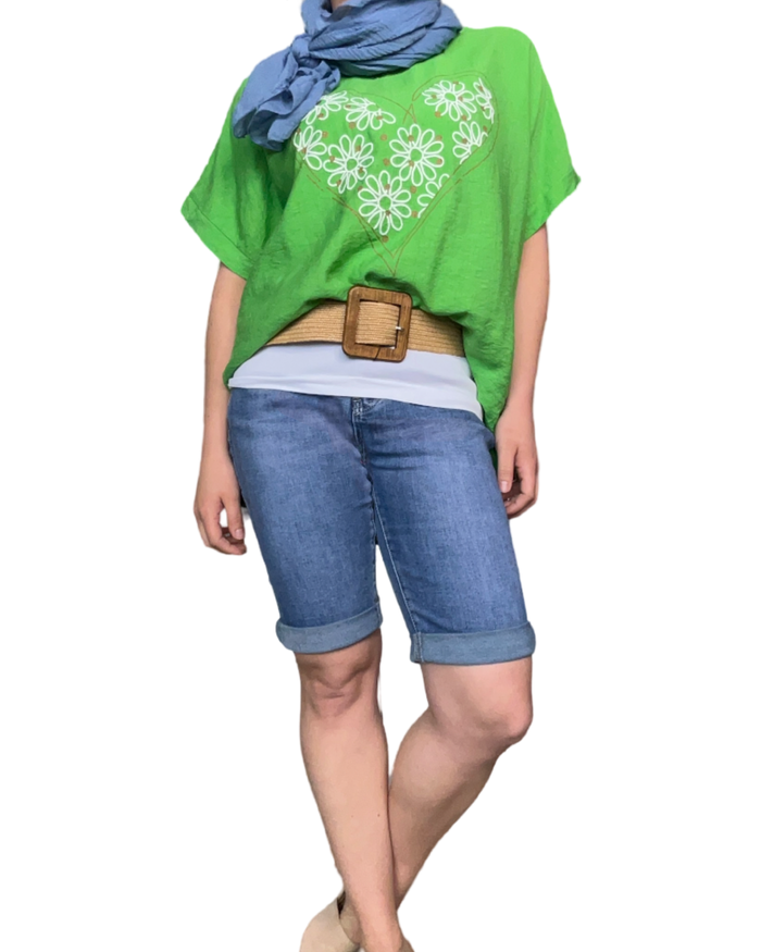 T-shirt vert pour femme avec imprimé d'un cœur composé de marguerites avec une ceinture en jute et un bermuda en jean.