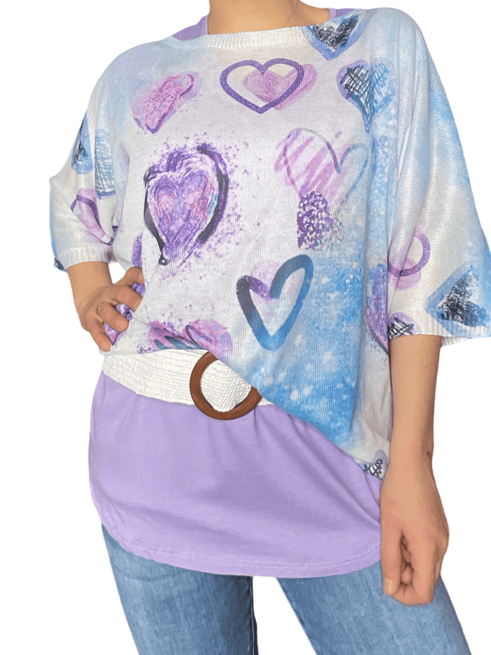 Chandail blanc pour femme avec imprimé de cœurs bleus et lilas avec ceinture blanche en jute et t-shirt lilas à l'intérieur. 