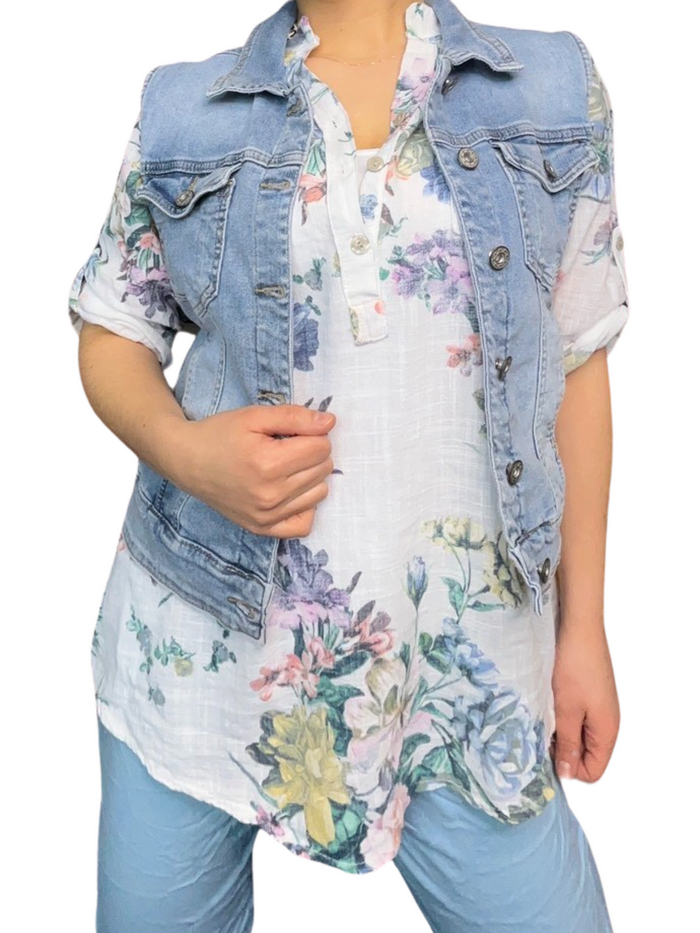 Blouse blanche pour femme avec imprimé florale de couleurs variées avec veste en jeans et pantalon bleu ciel.