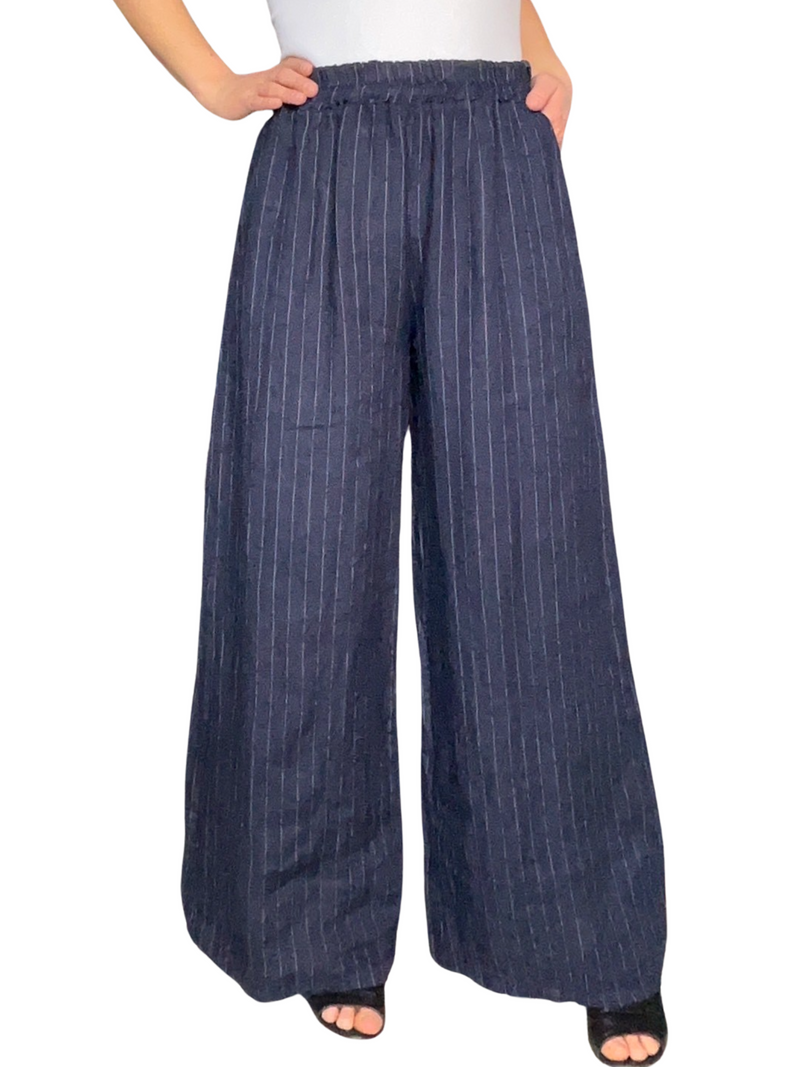 Pantalon pour femme droit bleu marin rayé en lin à taille élastique avec camisole gainante blanche à l'intérieur et sandales à talon noires.