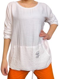 Chandail blanc pour femme à manche longue avec bas ajustable avec pantalon orange.
