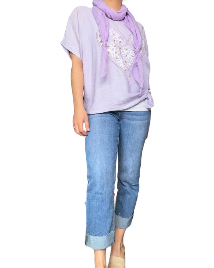 T-shirt lilas pour femme avec imprimé d'un cœur composé de marguerites avec un jean.