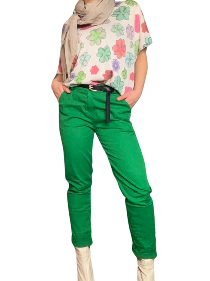 Pantalon cigarette vert pour femme avec ceinture noire avec chandail à manche courte, foulard beige et bottes beige.