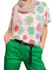 T-shirt blanc pour femme avec imprimé de fleurs multicolores avec foulard beige et pantalon vert.