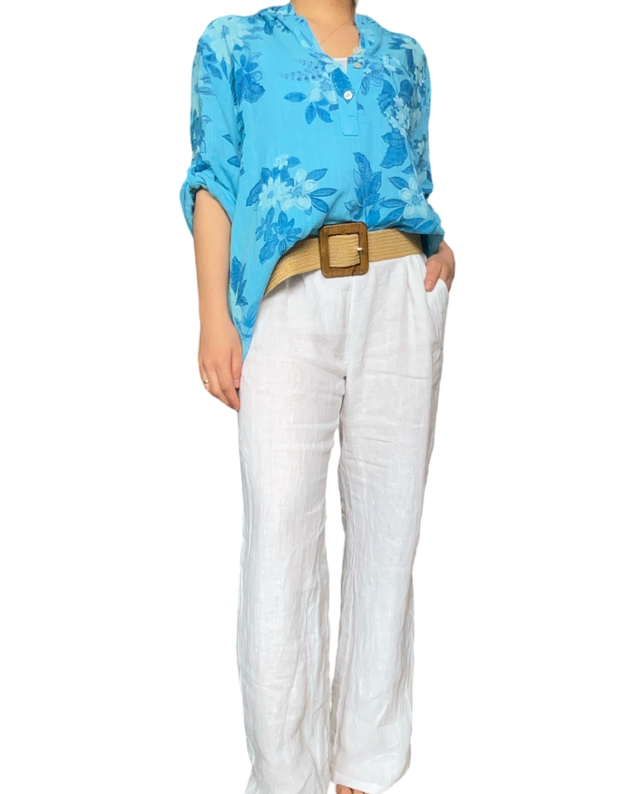 Blouse turquoise pour femme avec imprimé floral avec pantalon blanc en lin.