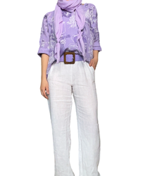 Pantalon droit blanc femme en lin à taille élastique avec cordon avec foulard lilas, chandail lilas et ceinture lilas en jute.