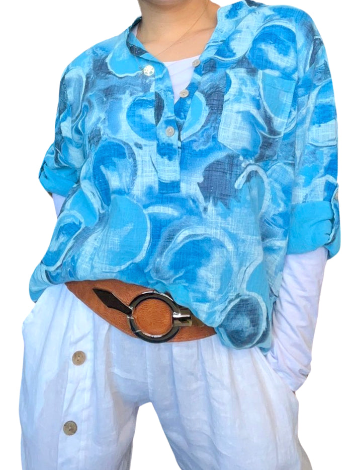 Blouse turquoise pour femme avec imprimé de ronds abstraits avec chandail à manche longue blanc à l'intérieur.