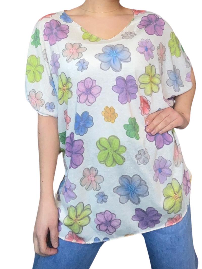 T-shirt blanc pour femme avec imprimé de fleurs multicolores portée over size avec des jeans. 