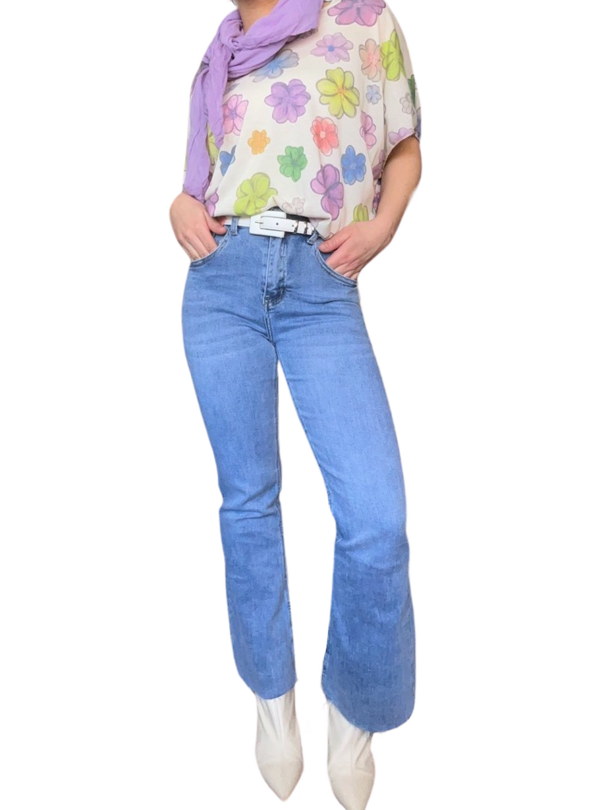 T-shirt blanc pour femme avec imprimé de fleurs multicolores avec jeans flare et bottes blanches. 