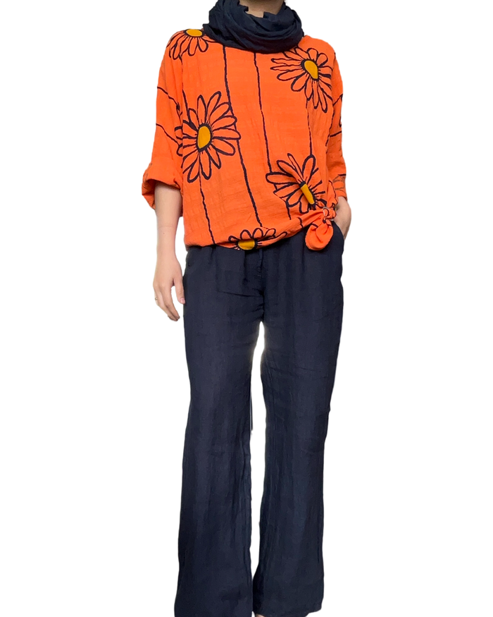 Chandail orange pour femme avec imprimé de tournesols avec pantalon bleu marin en lin.