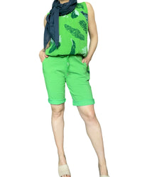 Bermuda vert pour femme à taille élastique avec cordon avec foulard bleu marin et camisole.
