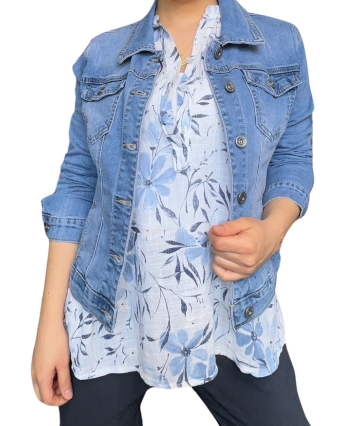 Blouse blanche sans manche avec imprimé de fleurs bleues pour femme avec veste en jeans.