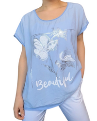 T-shirt bleu clair pour femme avec imprimé d'une fleur porté over size.