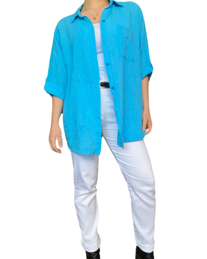 Chemise à manche 3/4 turquoise unie pour femme avec pantalon blanc.