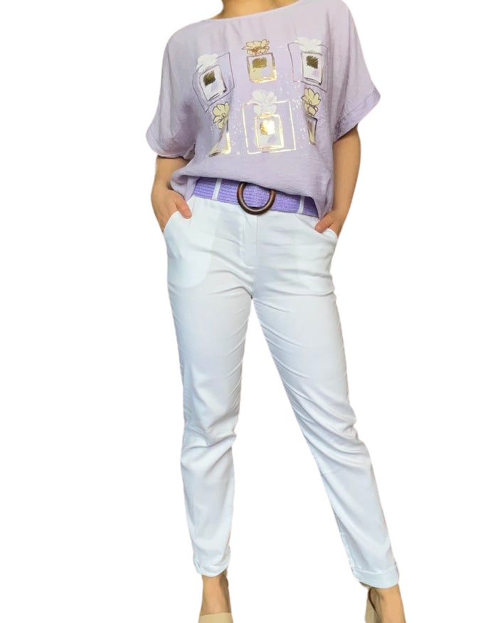 T-shirt lilas pour femme avec imprimé des cadres et des fleurs avec ceinture lilas en jute et pantalon blanc.