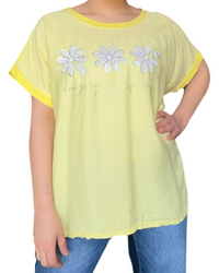 T-shirt jaune pour femme avec imprimé de trois fleurs blanches.