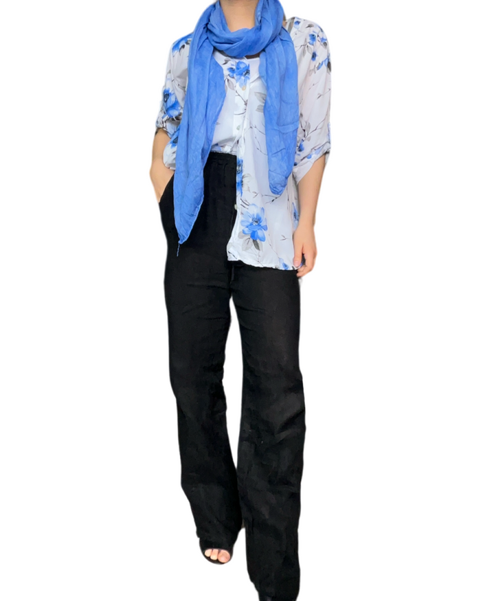 Chemise blanche avec imprimé de fleurs bleues et grises pour femme avec pantalon noir en lin.